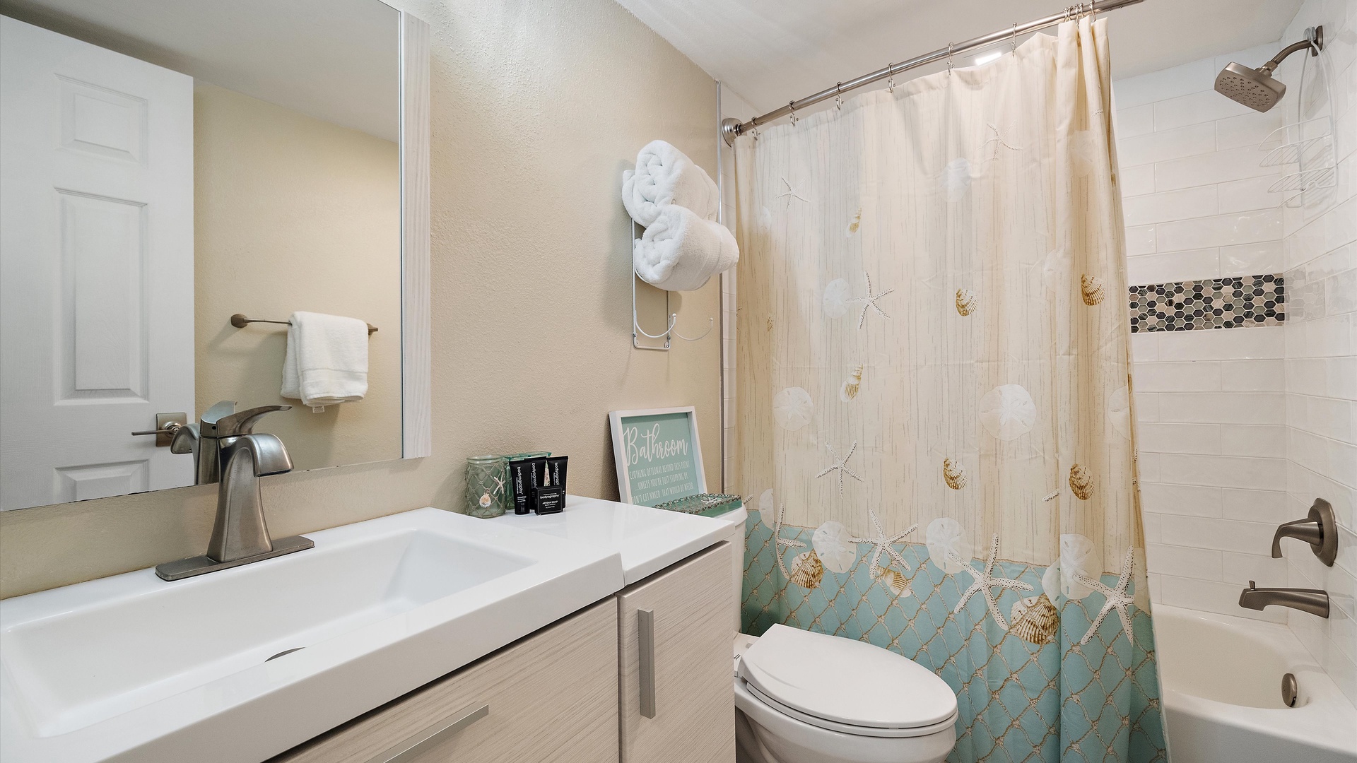Refresh in your coastal-themed guest bathroom, complete with beach-inspired touches and a soothing shower-tub combo. Fresh towels and beachy décor create a relaxing retreat after a day of adventure.