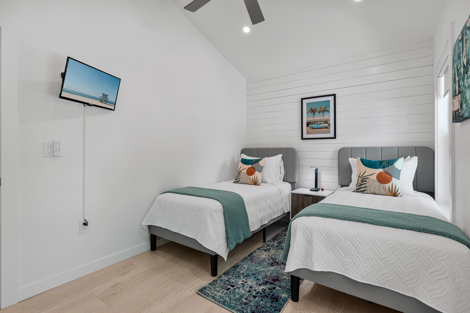 Unwind in your serene twin bedroom, where coastal charm meets comfort. Crisp linens, teal accents, and vaulted ceilings create a peaceful retreat after your day exploring.