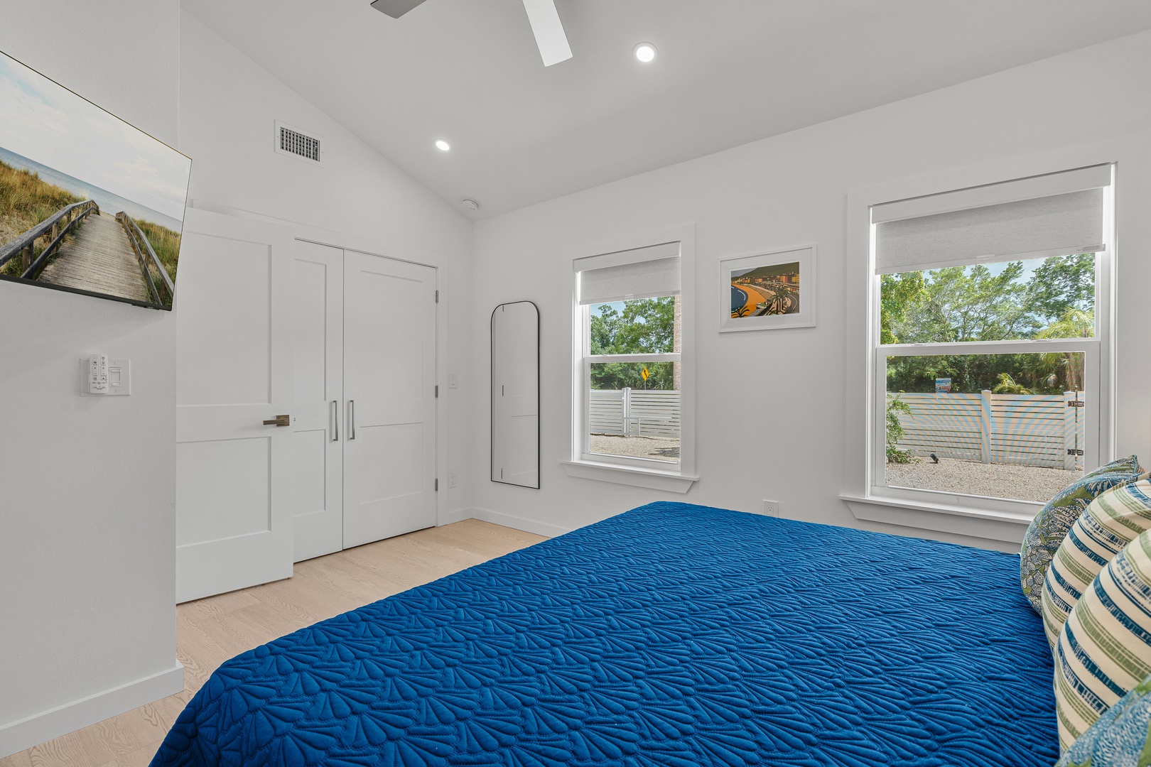 Relax in your bright, airy bedroom with comfy bedding, large windows for natural light, and a full-length mirror. Thoughtful coastal touches complete this serene space.