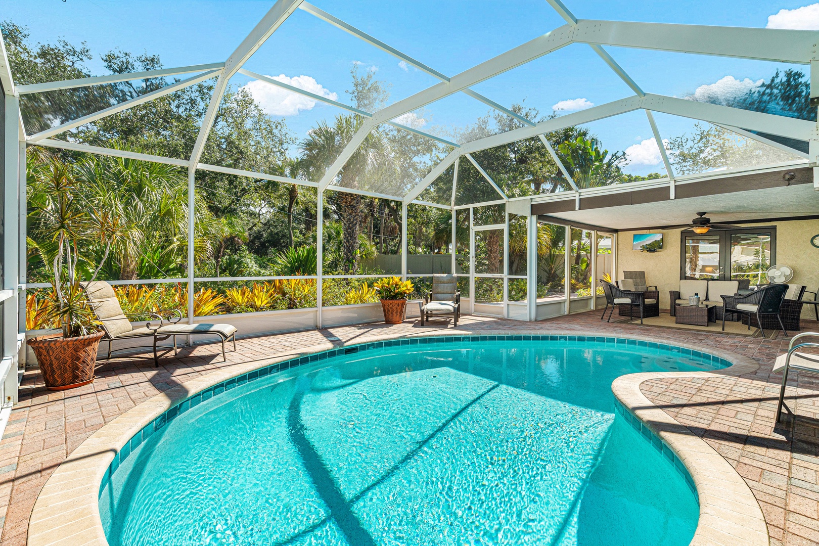 Your private screened pool awaits, framed by lush tropical landscaping and a sunny patio perfect for lounging. Step outside and let the Florida warmth embrace you in this tranquil backyard oasis.