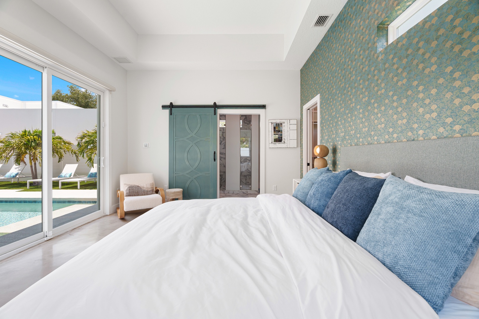 Wake up to sunshine streaming through your poolside bedroom, where coastal-inspired design meets modern comfort. The private patio doors invite you to step right from bed to your morning swim.
