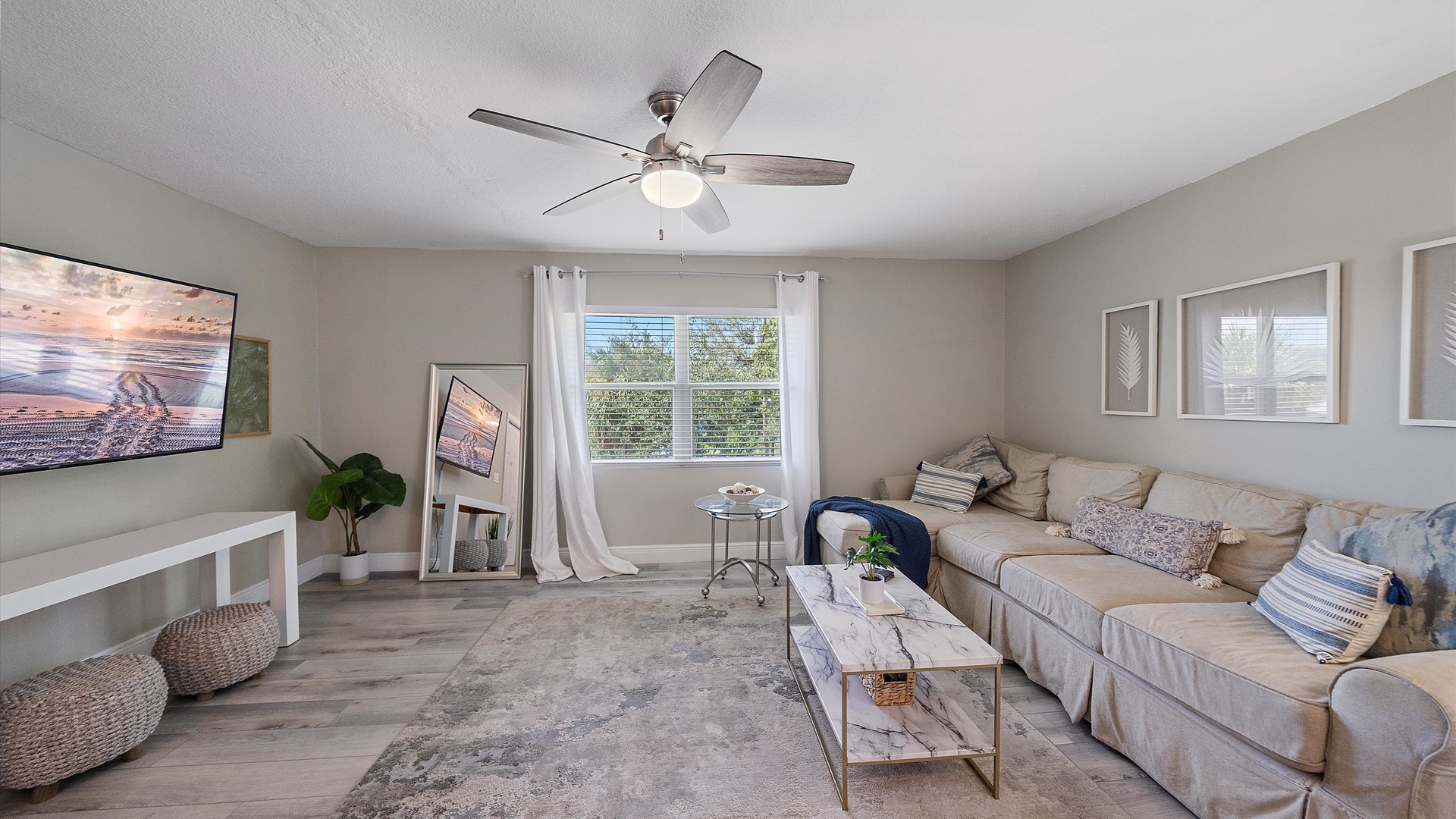 Sink into the plush sofa and unwind—this serene living room offers plenty of space to relax, with soft natural light and coastal-inspired touches that make you feel right at home.