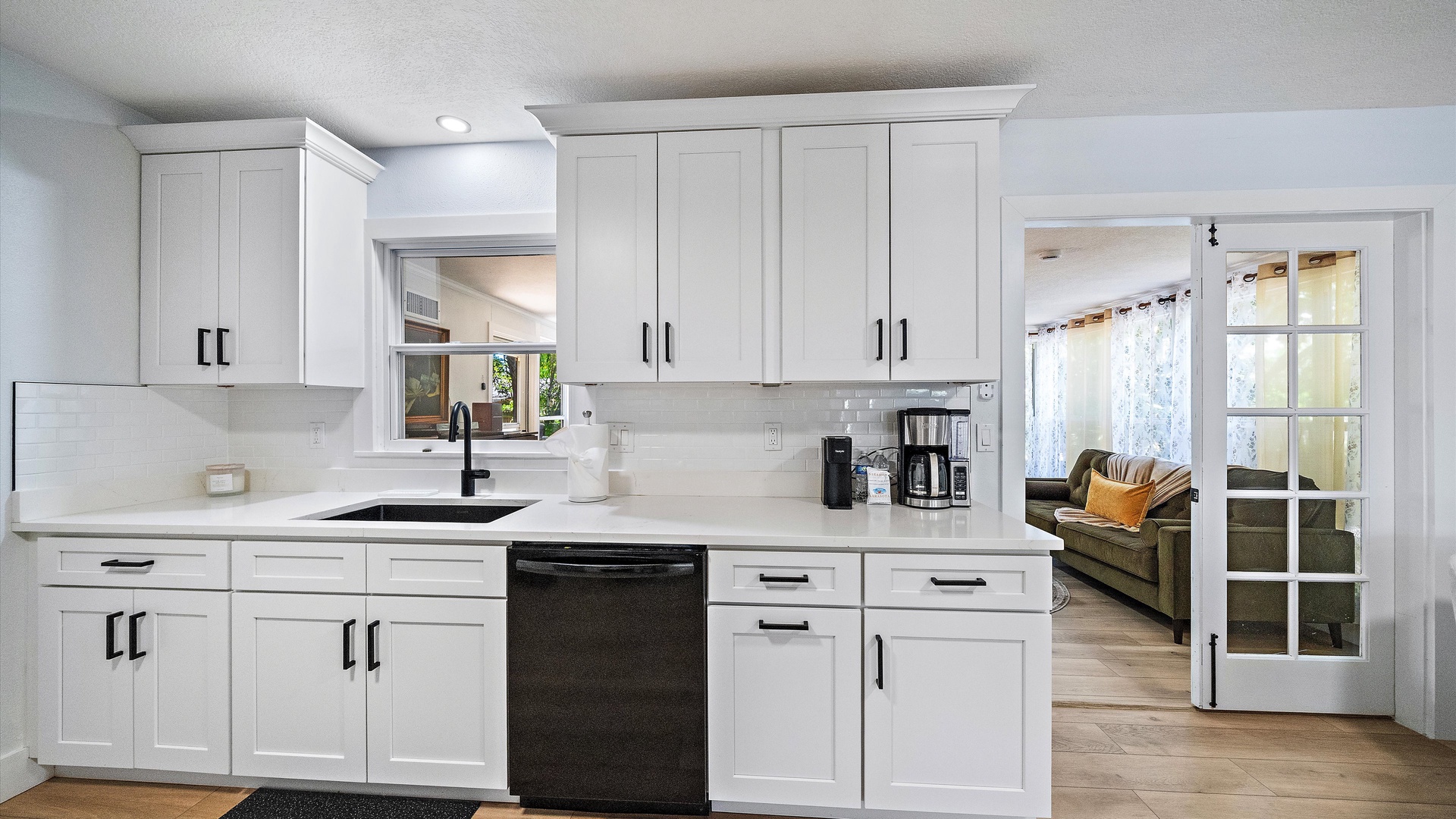 Step into your bright, fully equipped kitchen with crisp white cabinetry, modern appliances, and sleek countertops—perfect for preparing morning coffee or home-cooked meals during your stay.