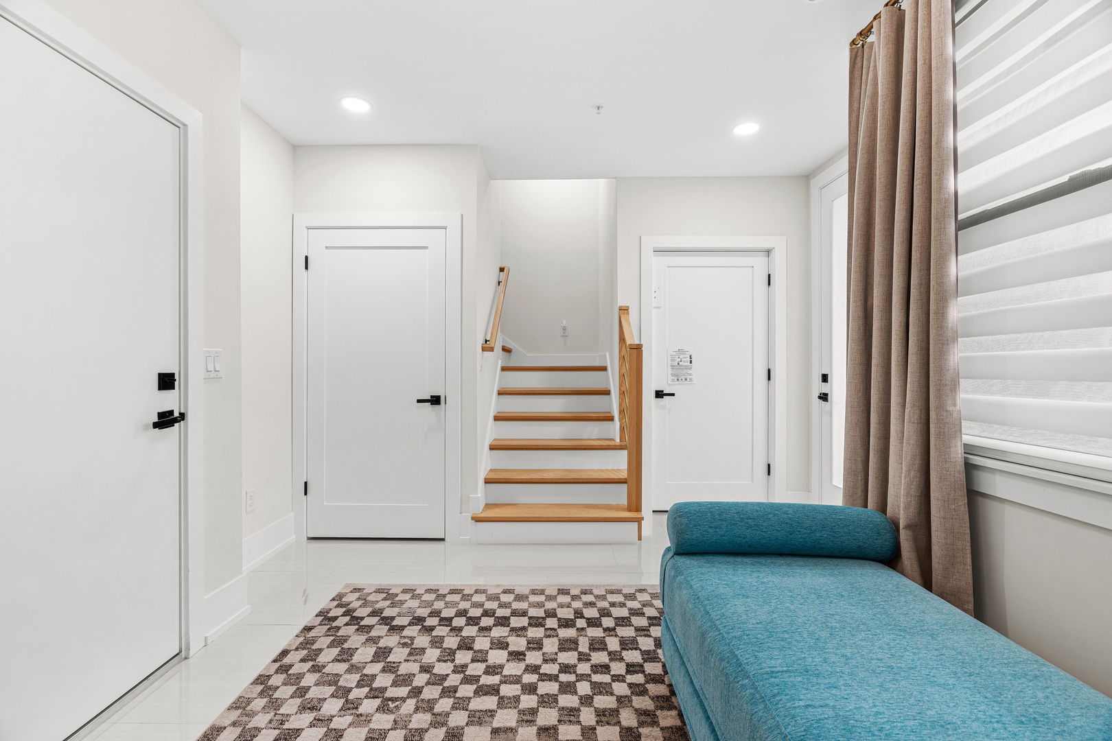 Step into your bright, modern entryway where a cozy turquoise lounge invites you to unwind immediately.