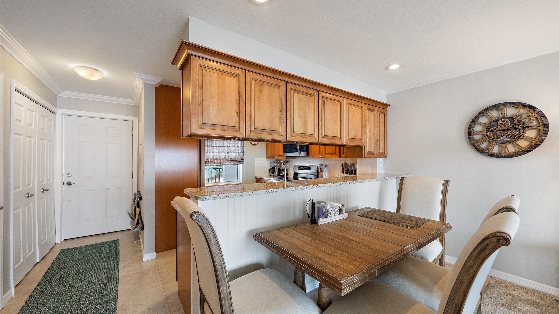 A comfortable dining space for four, framed by neutral upholstery and warm wood finishes. Its position beside the kitchen keeps the main living area open and connected.