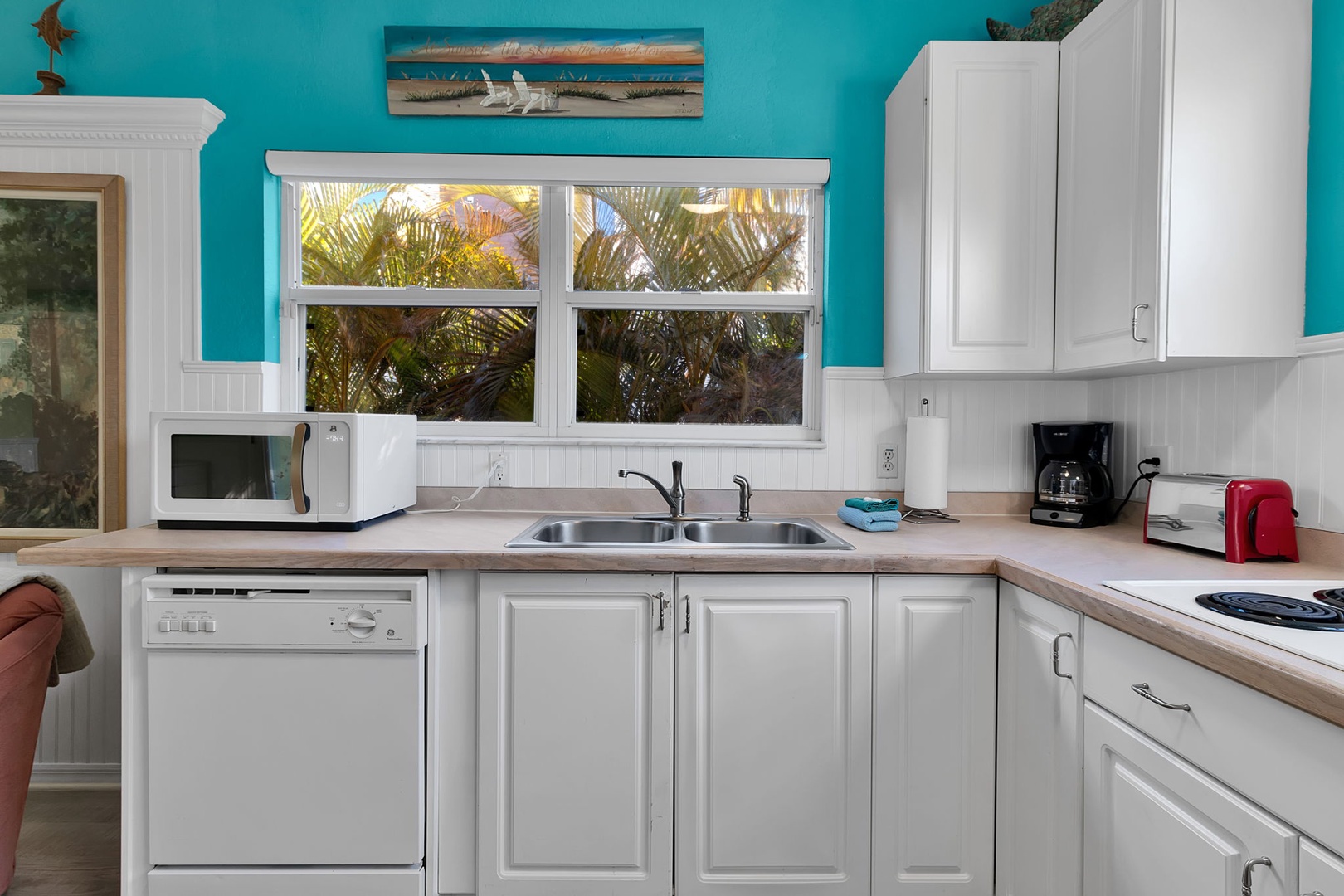 Your fully equipped kitchen awaits, bright and cheerful with palm trees swaying just outside the window, perfect for whipping up tropical breakfasts before heading to the beach.