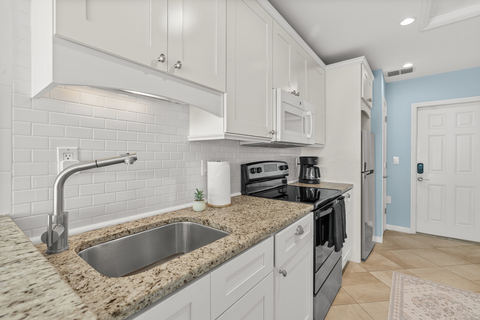 Your fully equipped kitchen features granite countertops, stainless steel appliances, and subway tile backsplash for effortless meal preparation.