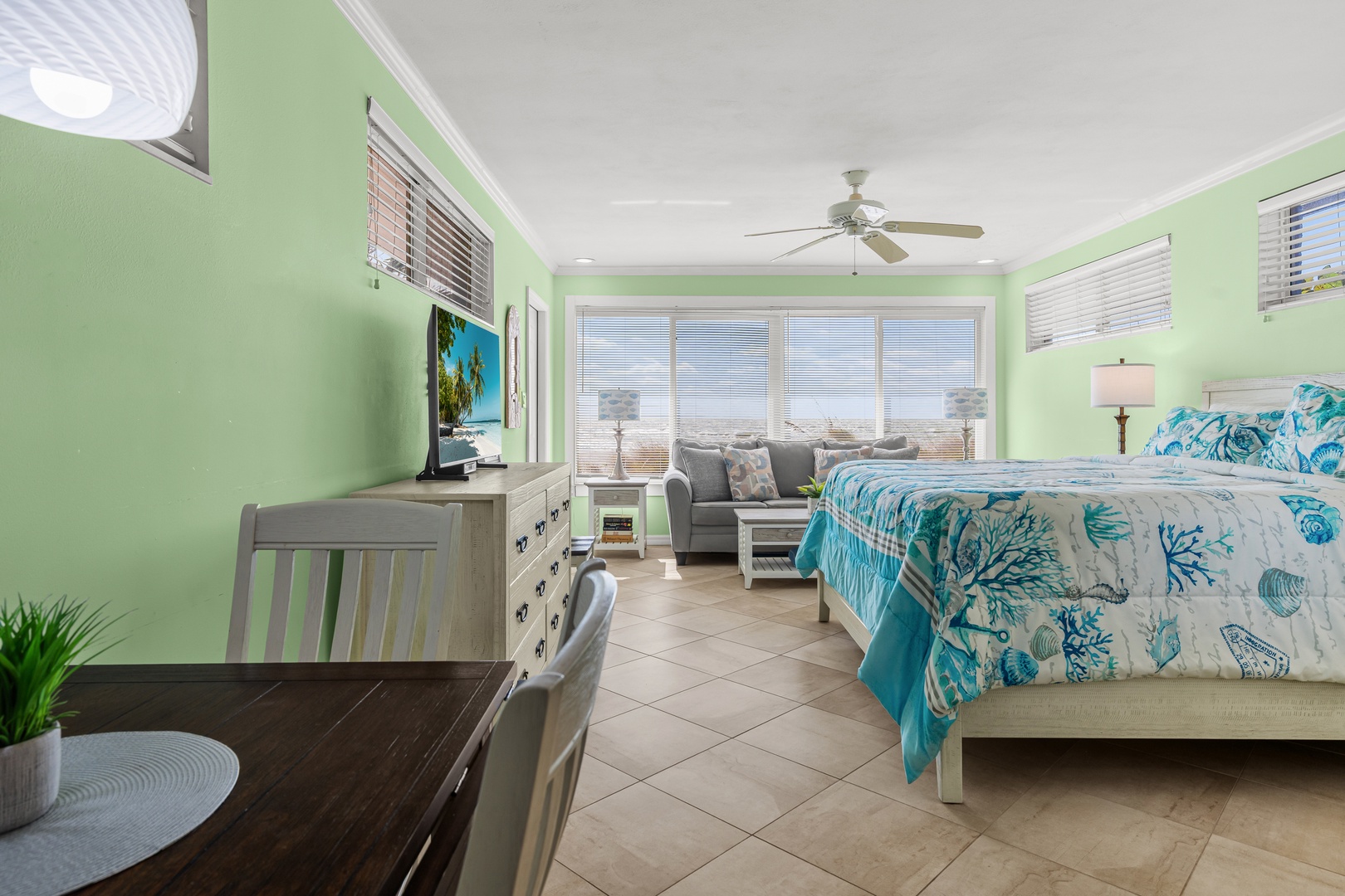 Unwind in your cheerful coastal retreat with ocean-themed bedding, comfortable seating, and refreshing sea breezes from your private space.