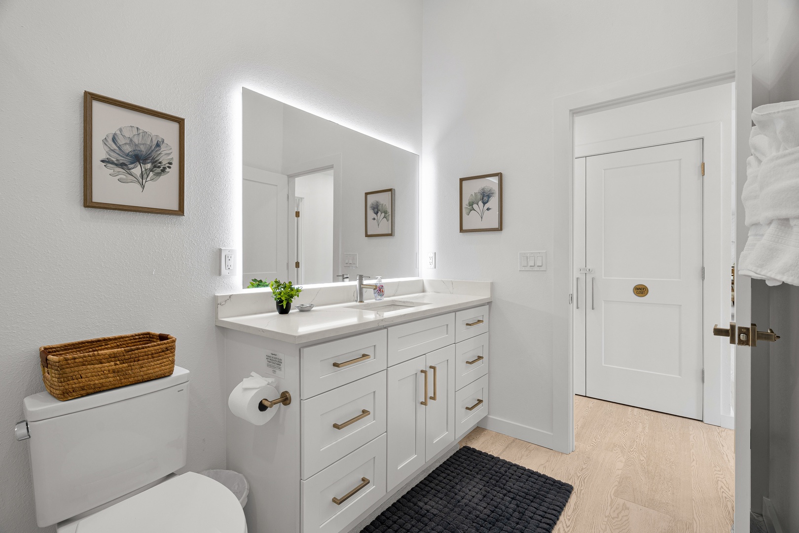 Step into your beautifully appointed bathroom with elegant dual vanities, soft LED mirror lighting, and thoughtful touches like botanical artwork that create a spa-like retreat for your morning and evening routines.