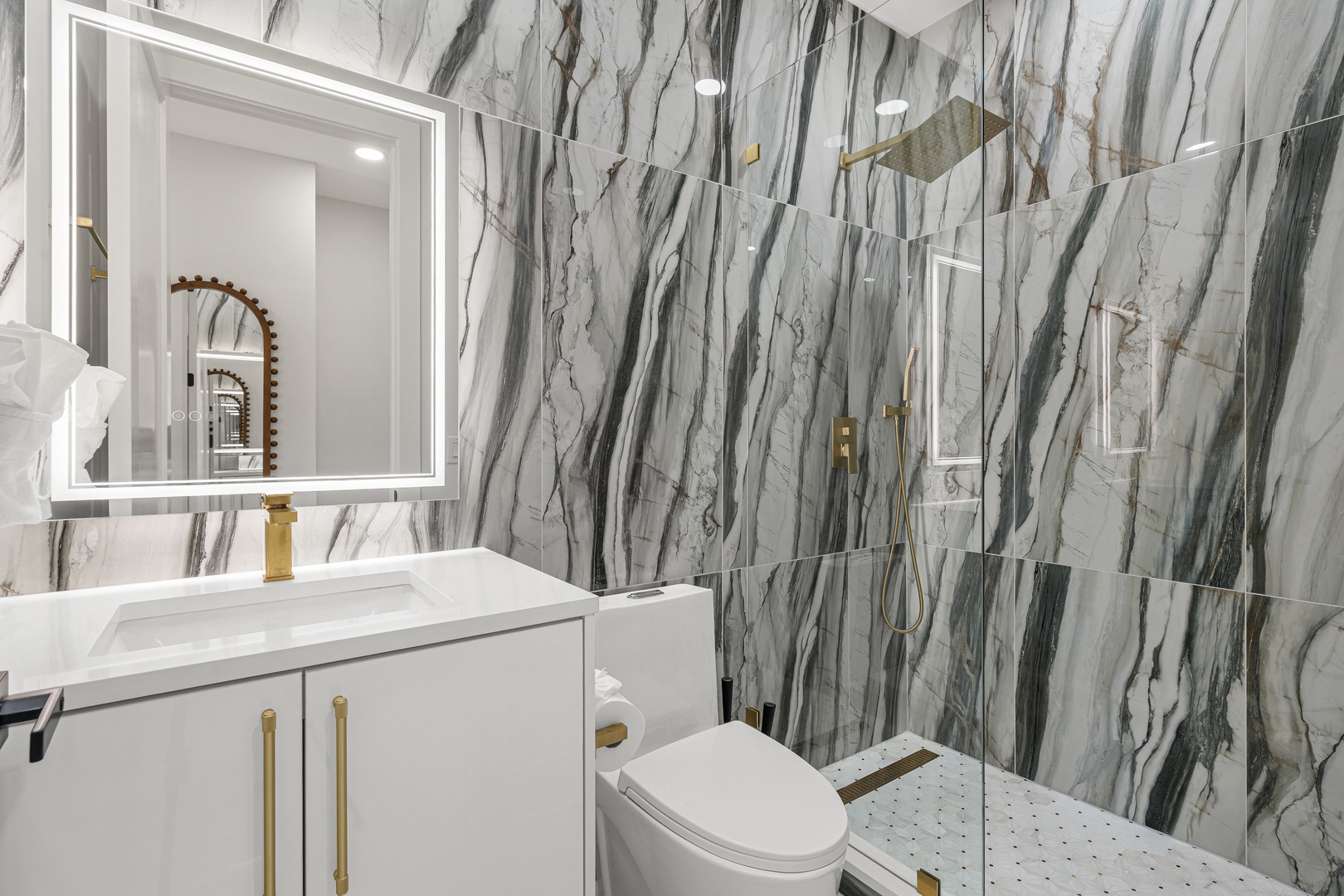 Step into your private sanctuary with dramatic marble walls and elegant gold fixtures that create a spa-like atmosphere for your morning and evening rituals.