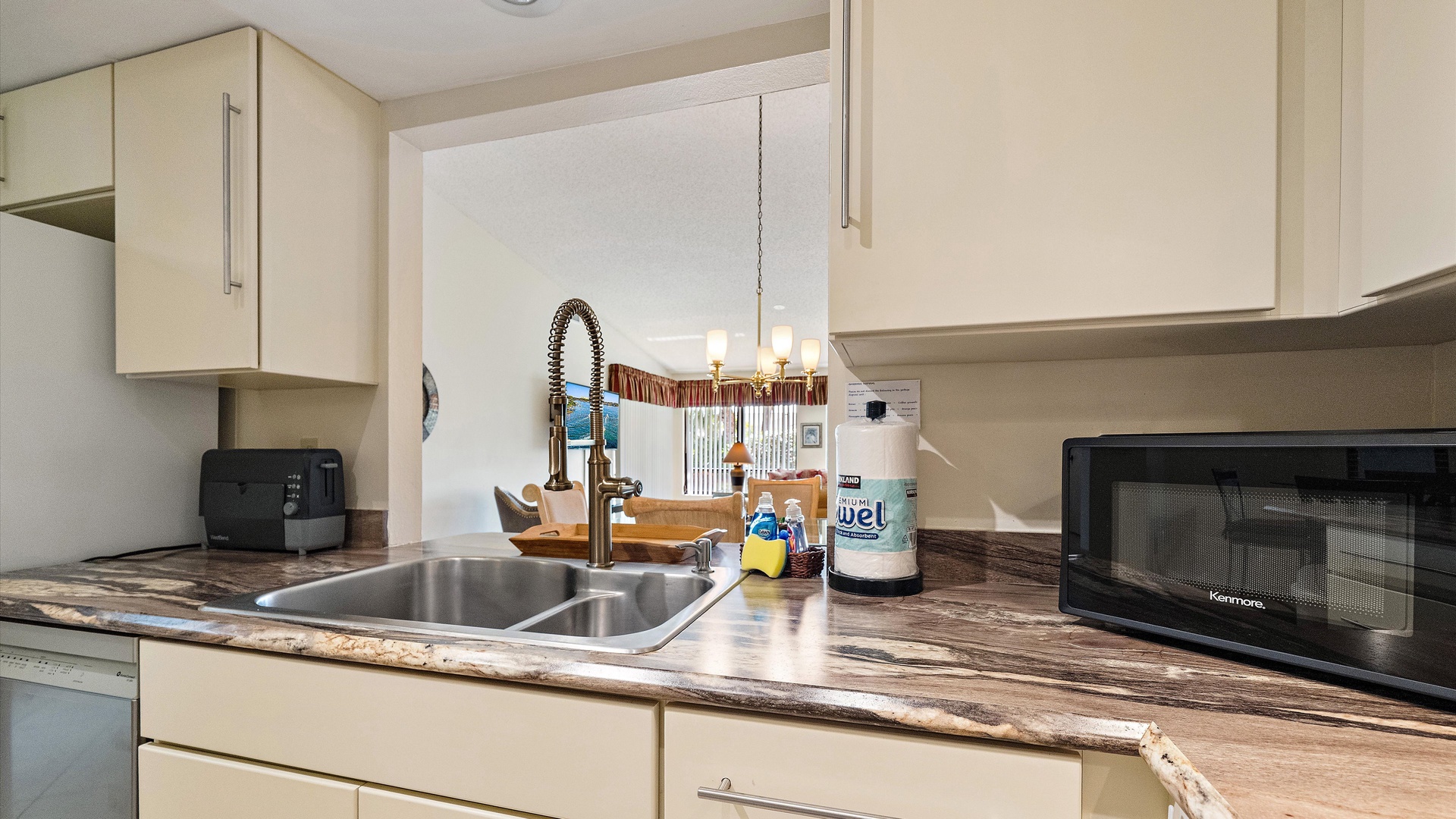 Your fully equipped kitchen features modern amenities and ample counter space, making meal prep a breeze with a microwave, coffee maker, and sleek double sink ready for your use.
