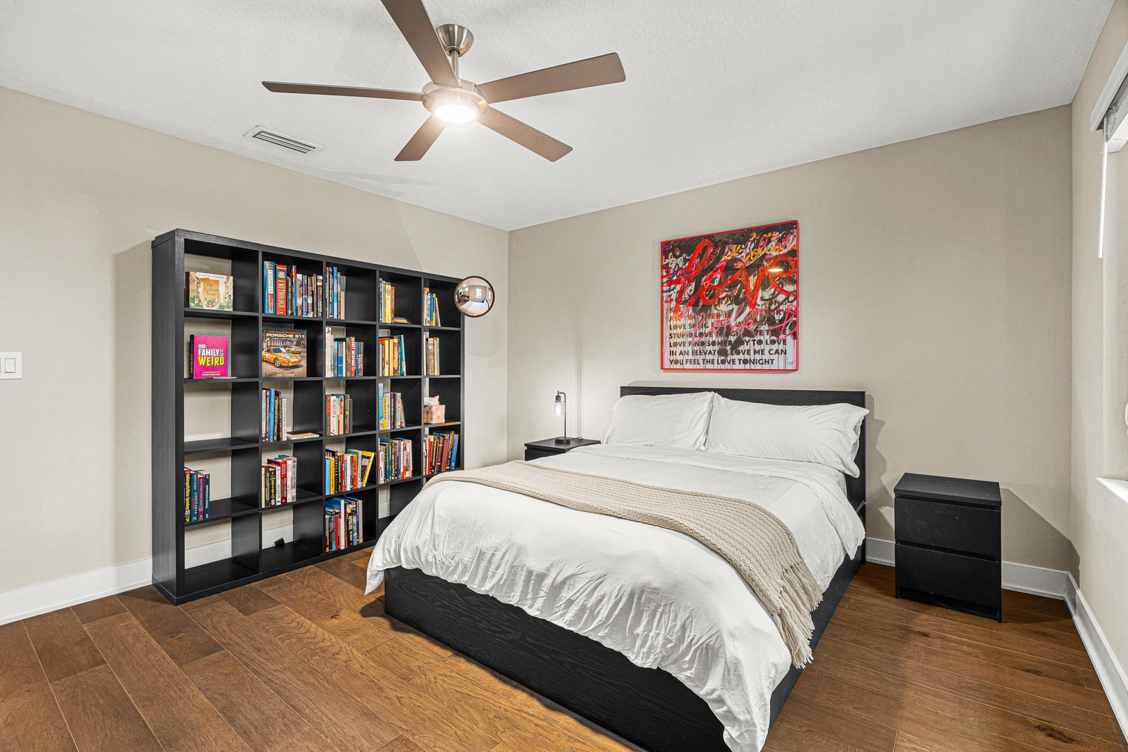 Your bedroom offers a peaceful retreat with a plush queen bed, thoughtful lighting, and an inspiring bookshelf stocked with reads for quiet evenings. The ceiling fan keeps you comfortable all year round.