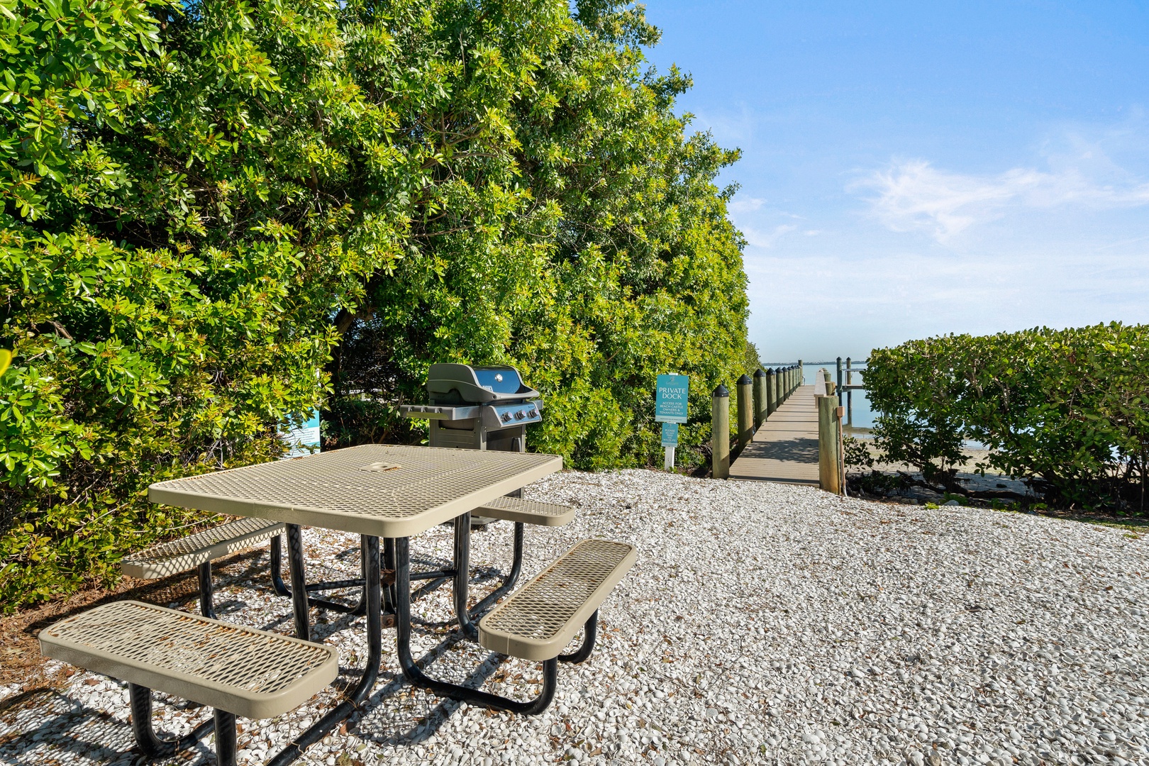 Outdoor area with picnic table, propane grill, and access to the bay.
