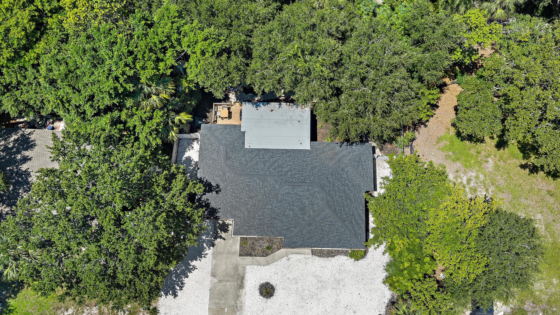 Aerial view of the property nestled among lush trees, offering a secluded retreat with natural surroundings and easy access to scenic walking paths.