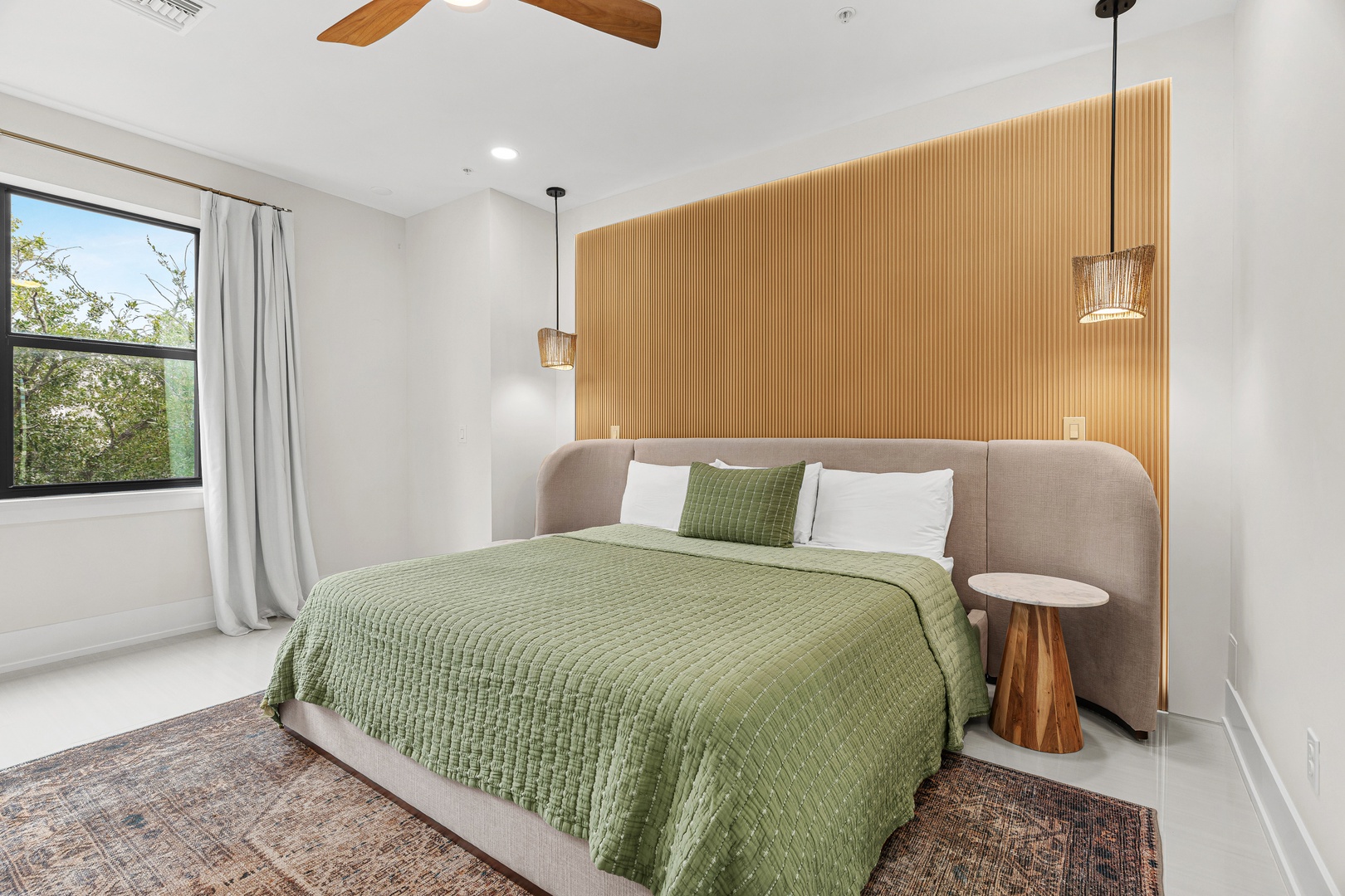 Your peaceful bedroom retreat features a plush bed, warm wood accents, and natural light streaming through the window—perfect for restful mornings and relaxing evenings.