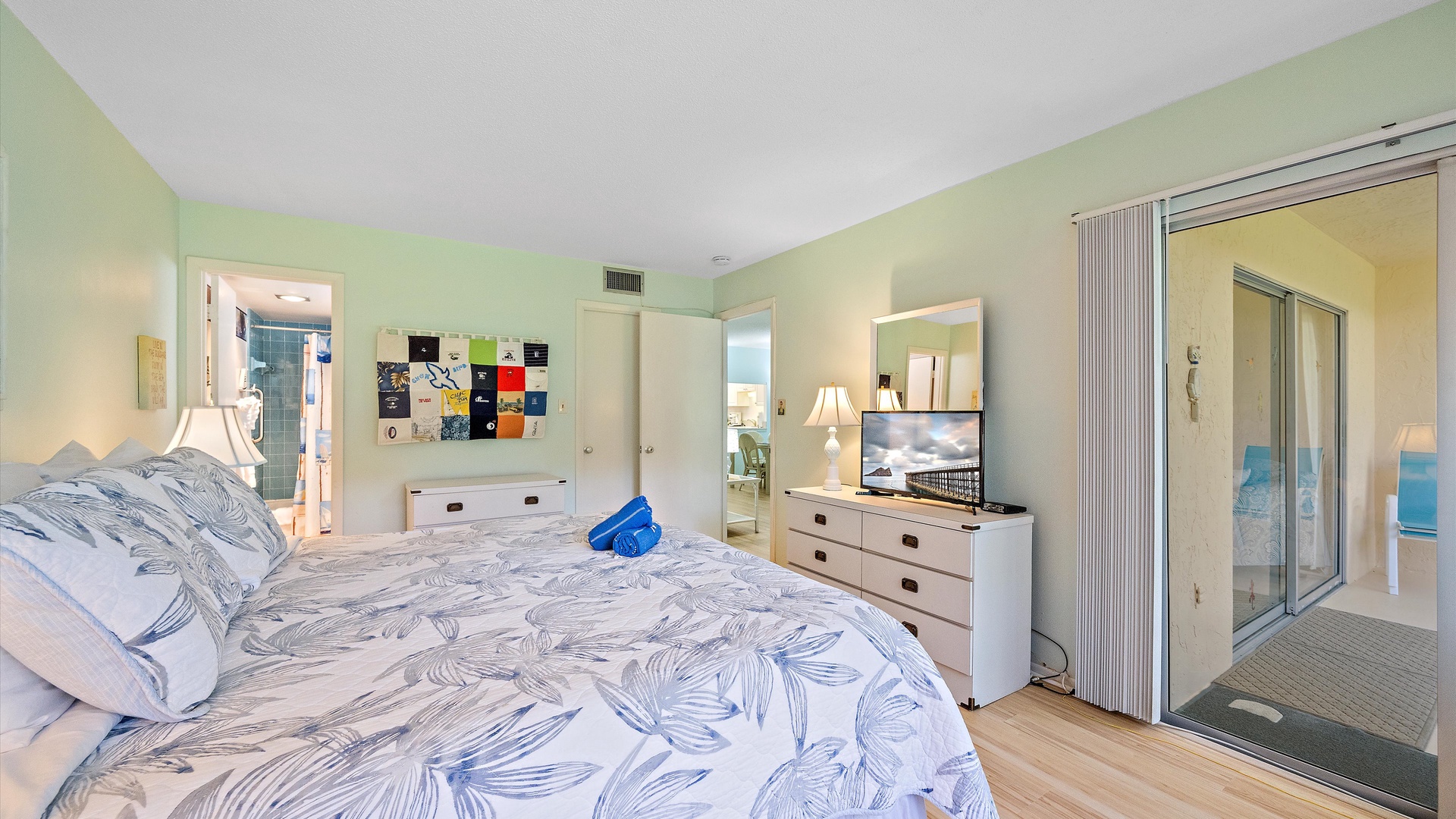 Relax in your bright, coastal-inspired retreat with a plush king bed, calming ocean-blue accents, and direct access to your private balcony—perfect for unwinding after beach days.