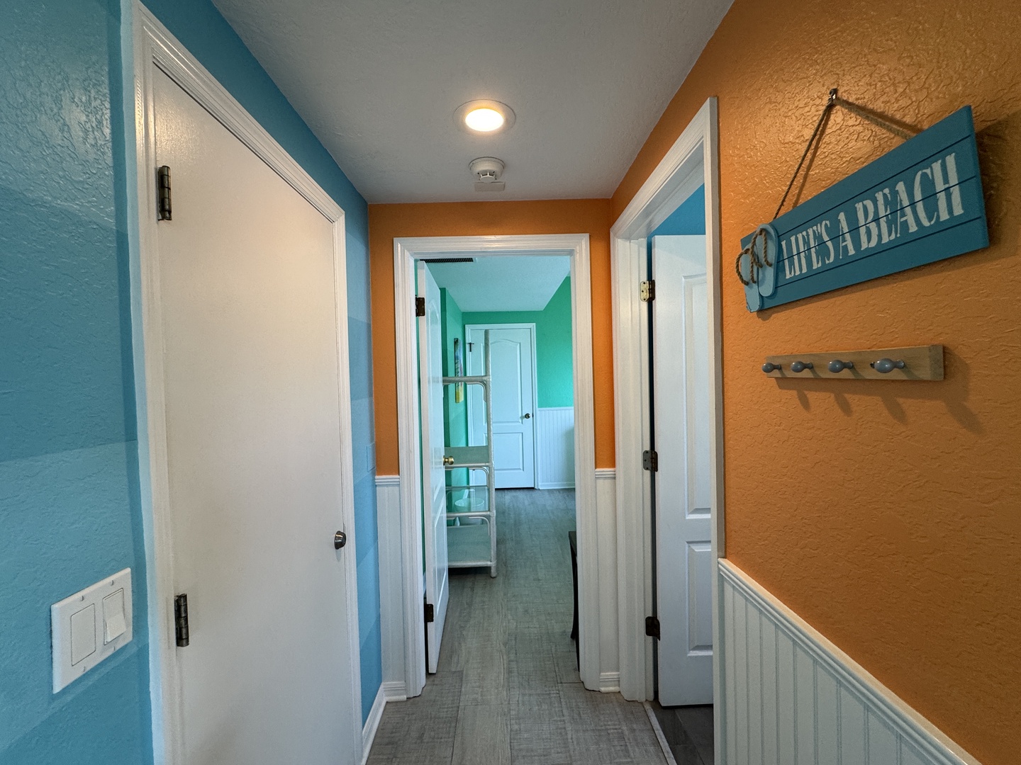 Cheerful coastal vibes greet you the moment you step inside, with playful pops of turquoise and tangerine setting a relaxed, beachy tone. The bright hallway leads you toward your comfortable retreat, where rest and relaxation await.