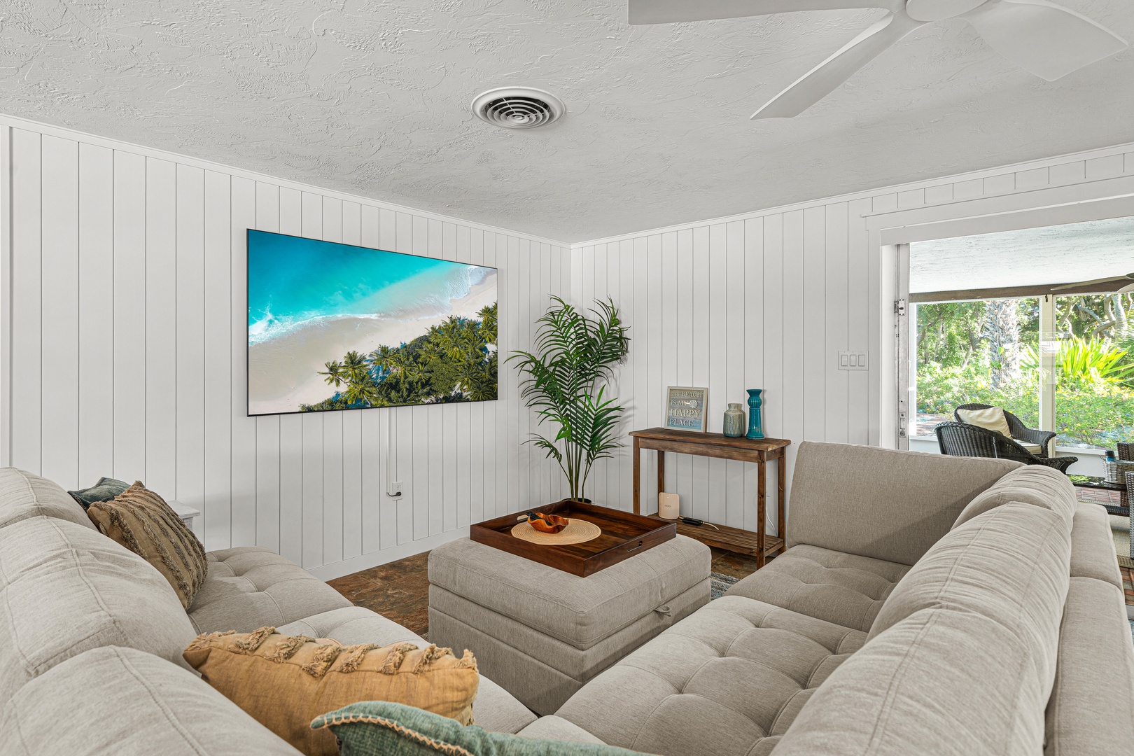 Sink into plush sofas in your bright, airy living room where natural light and tropical breezes flow through. The peaceful outdoor patio beckons you to extend your relaxation beyond these cozy walls.