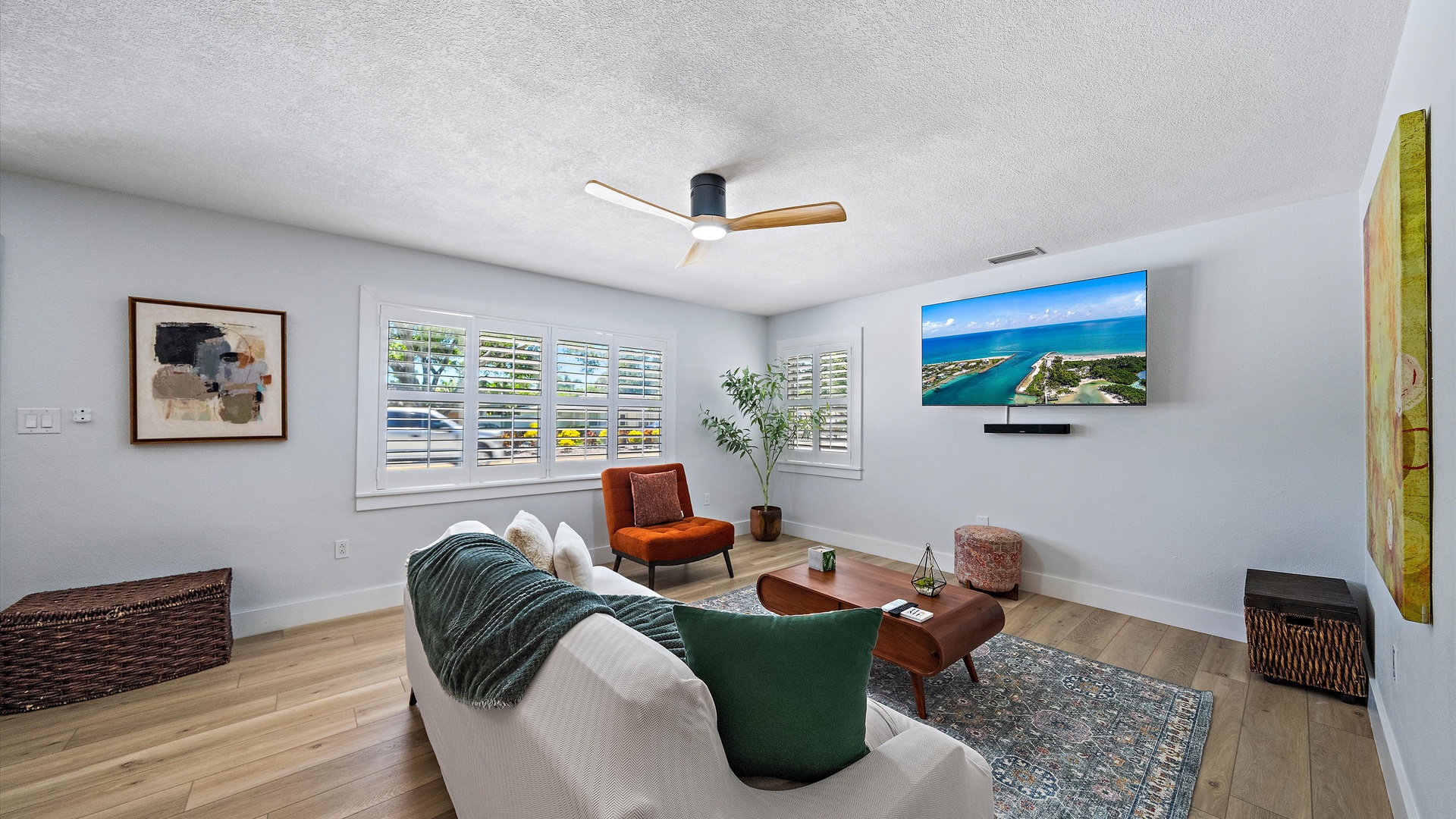 Sink into the plush sofa and unwind in your bright, modern living room. Natural light streams through elegant shutters, while the ceiling fan keeps things comfortable year-round. Your perfect home base awaits.