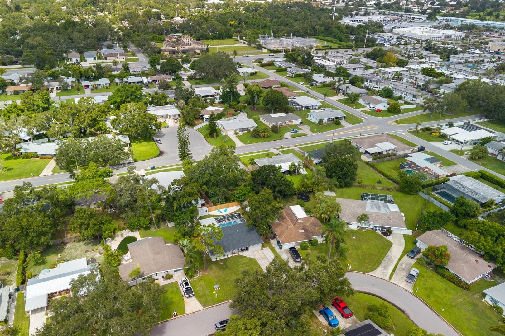 Aerial view of a peaceful residential neighborhood with tree-lined streets, well-maintained homes, and green spaces throughout the community.