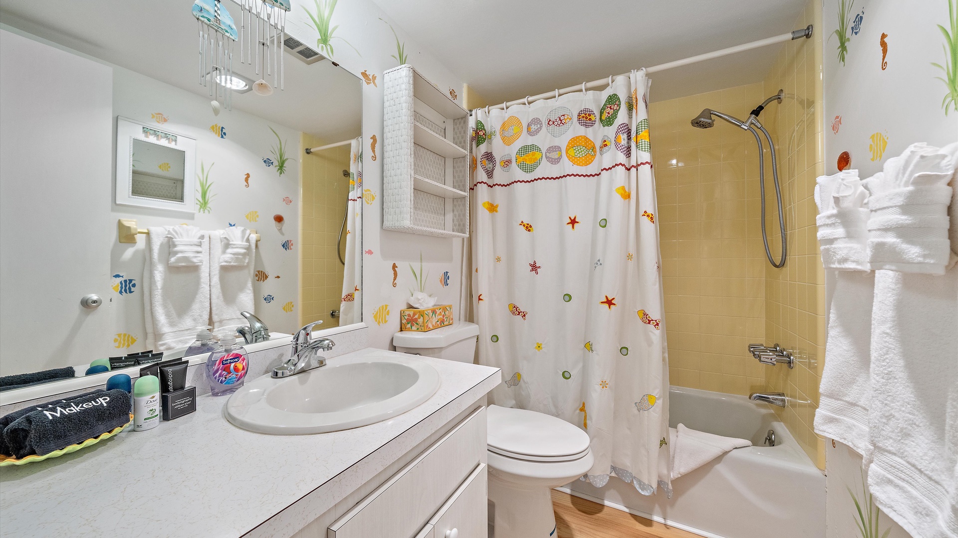 Your bathroom features cheerful sea-themed decor, a full tub-shower combo, fresh towels, and plenty of counter space for your daily routine.
