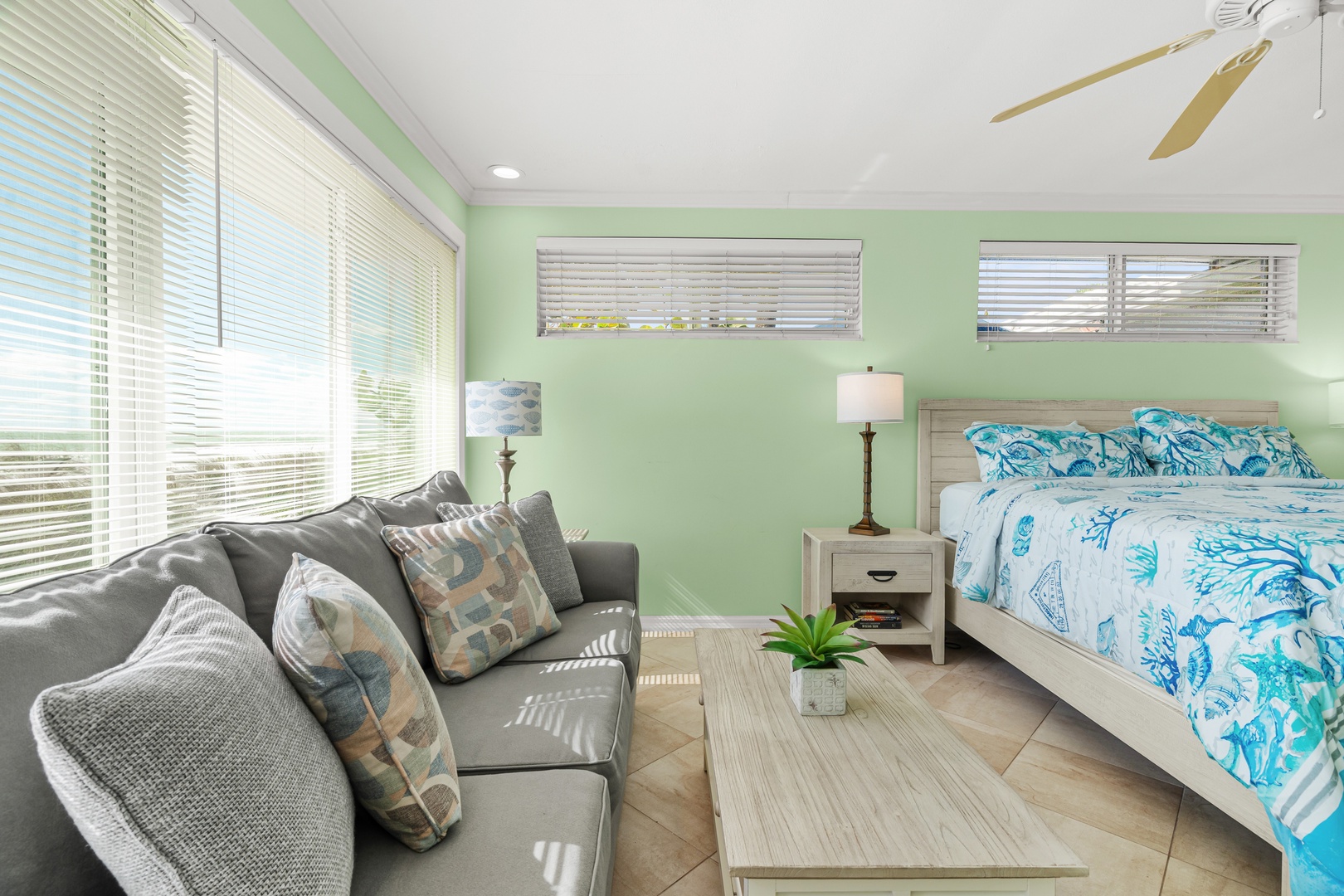 Your bright studio features a cozy sofa, king bed, and ocean-themed linens—perfect for relaxing after sunny beach days.