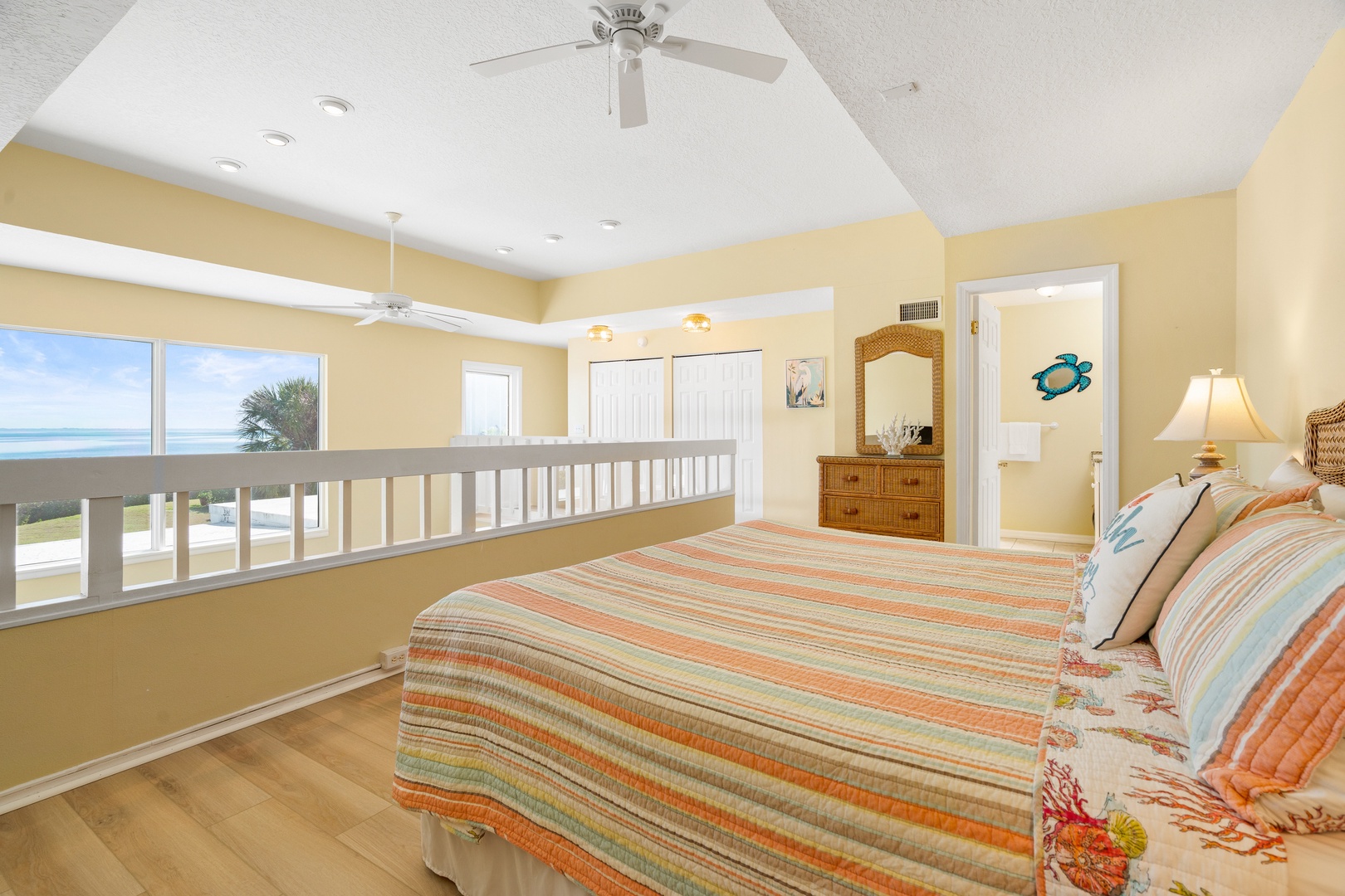 Wake up to ocean breezes in your coastal bedroom, where striped linens and warm yellow walls create a sunny retreat with stunning sea views.