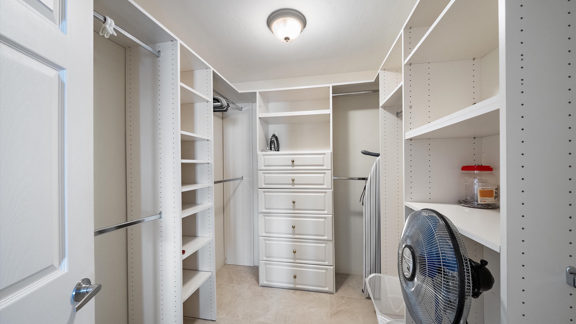 A spacious walk-in closet gives an extended stay room to settle in. Hanging space, shelving, and drawers keep clothing and personal belongings neatly organized.