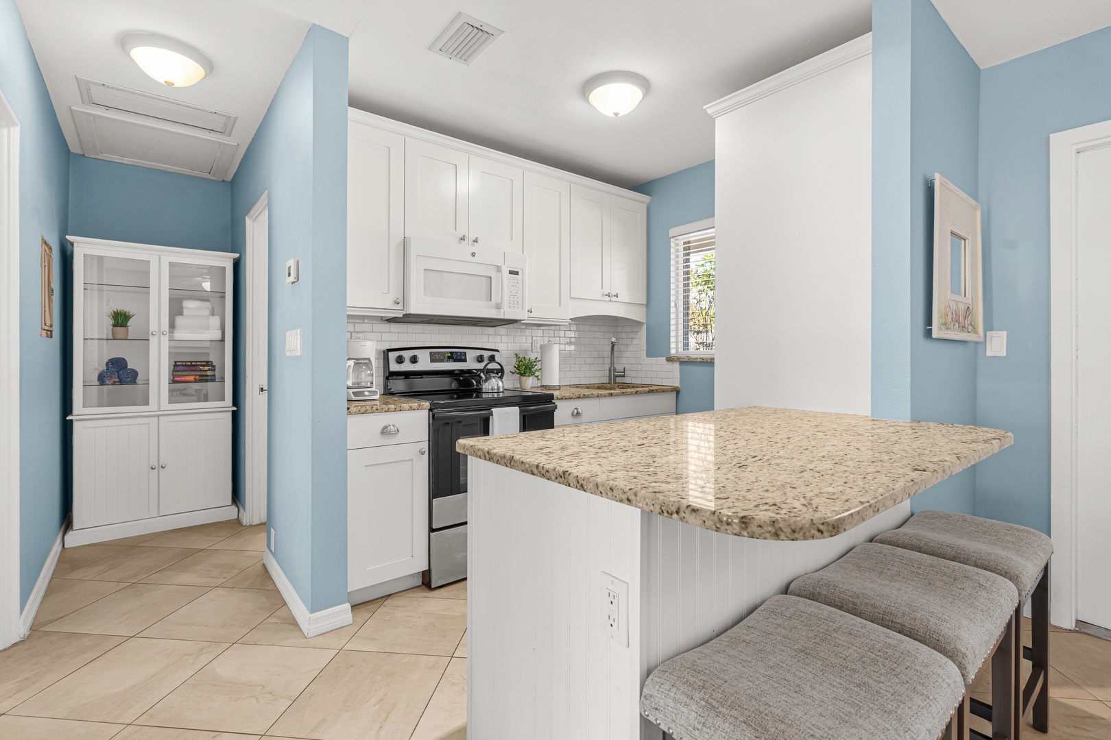 Step into your bright, fully-equipped kitchen with granite counters, modern appliances, and a breakfast bar perfect for morning coffee.