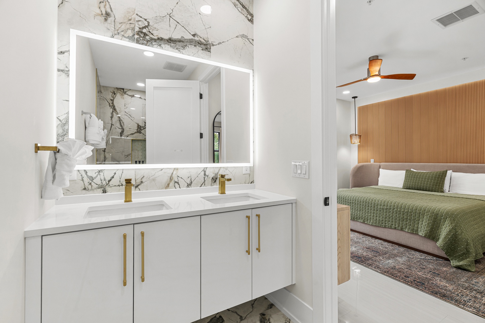 Step from your elegant bathroom with its marble accents and gold fixtures into the adjoining bedroom, where modern design meets comfort and style.