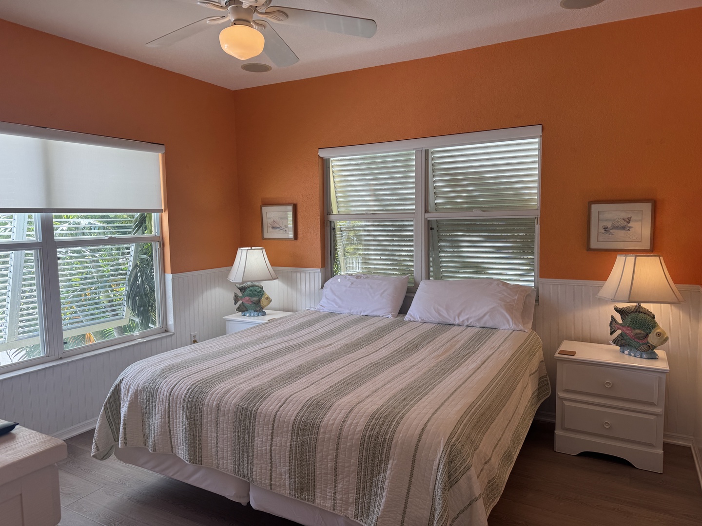 Slip into your cozy retreat, where warm coastal tones and soft bedding invite you to unwind. The gentle ceiling fan keeps you comfortable while natural light filters through the windows, creating the perfect sanctuary for your getaway.