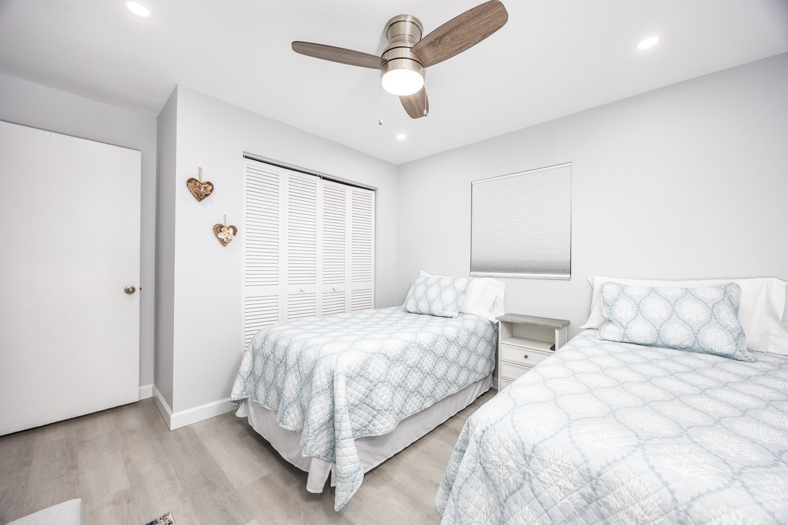 Rest peacefully in your bright twin bedroom with soft blue linens and gentle ceiling fan breeze.