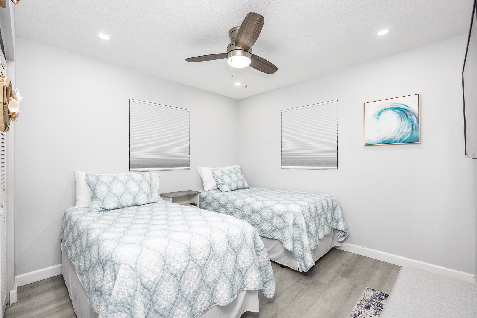 Rest comfortably in your twin bedroom with ocean-inspired decor, ceiling fan, and blackout blinds for peaceful sleep.
