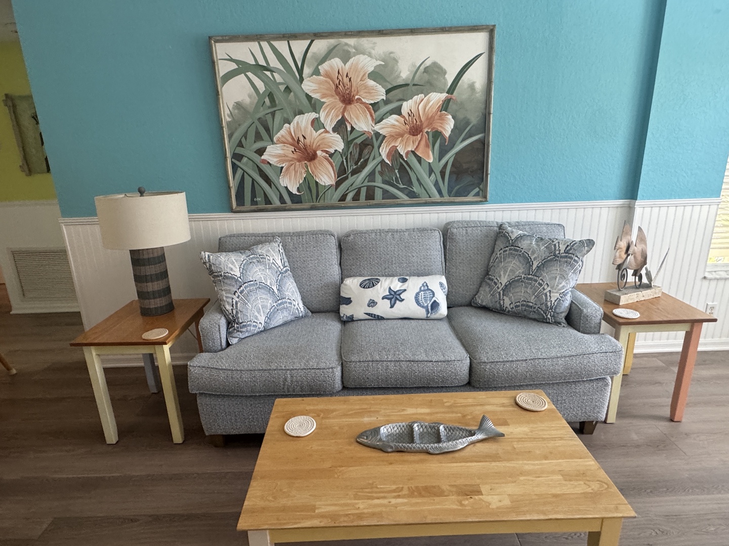 Settle into your comfortable living room where coastal decor meets homey charm. Sink into the plush sofa surrounded by beachy accents and warm wood tones—your perfect spot to unwind after a day of adventure.