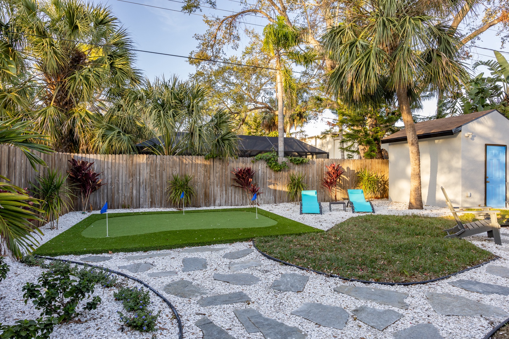 Practice your putting on your private mini golf course surrounded by tropical palms and colorful landscaping in this unique backyard oasis.