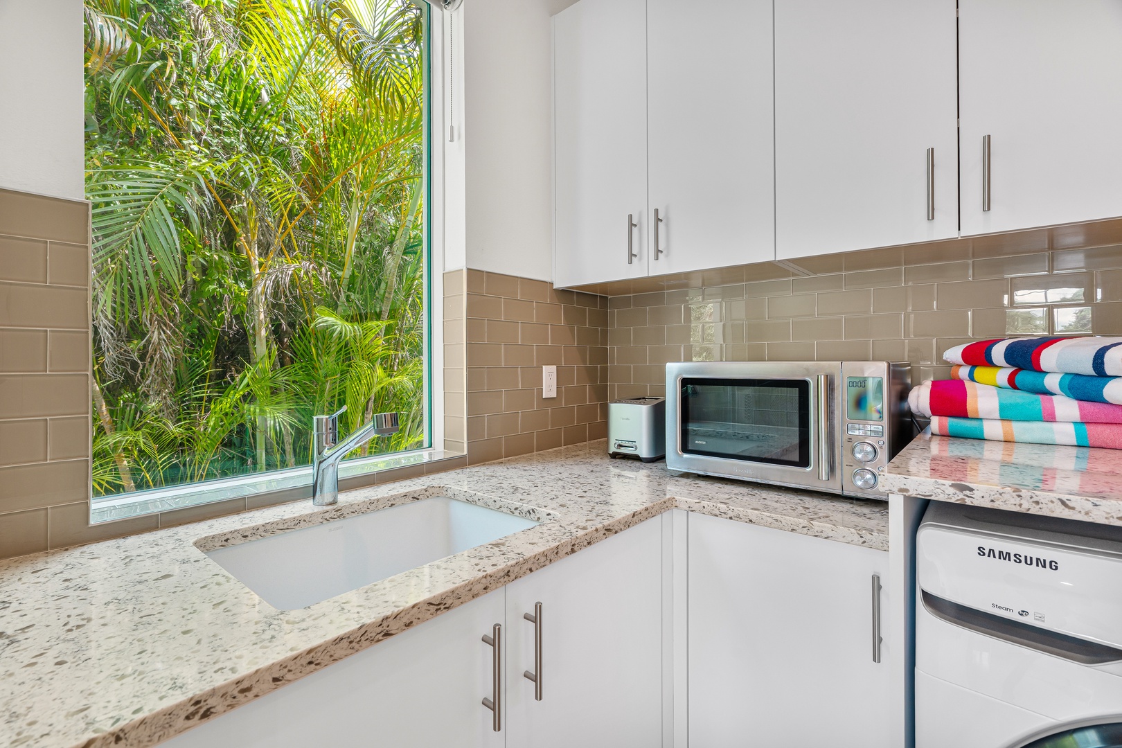 Prepare your favorite meals in this fully-equipped kitchen while enjoying lush tropical greenery through the window—a peaceful backdrop for your home away from home.