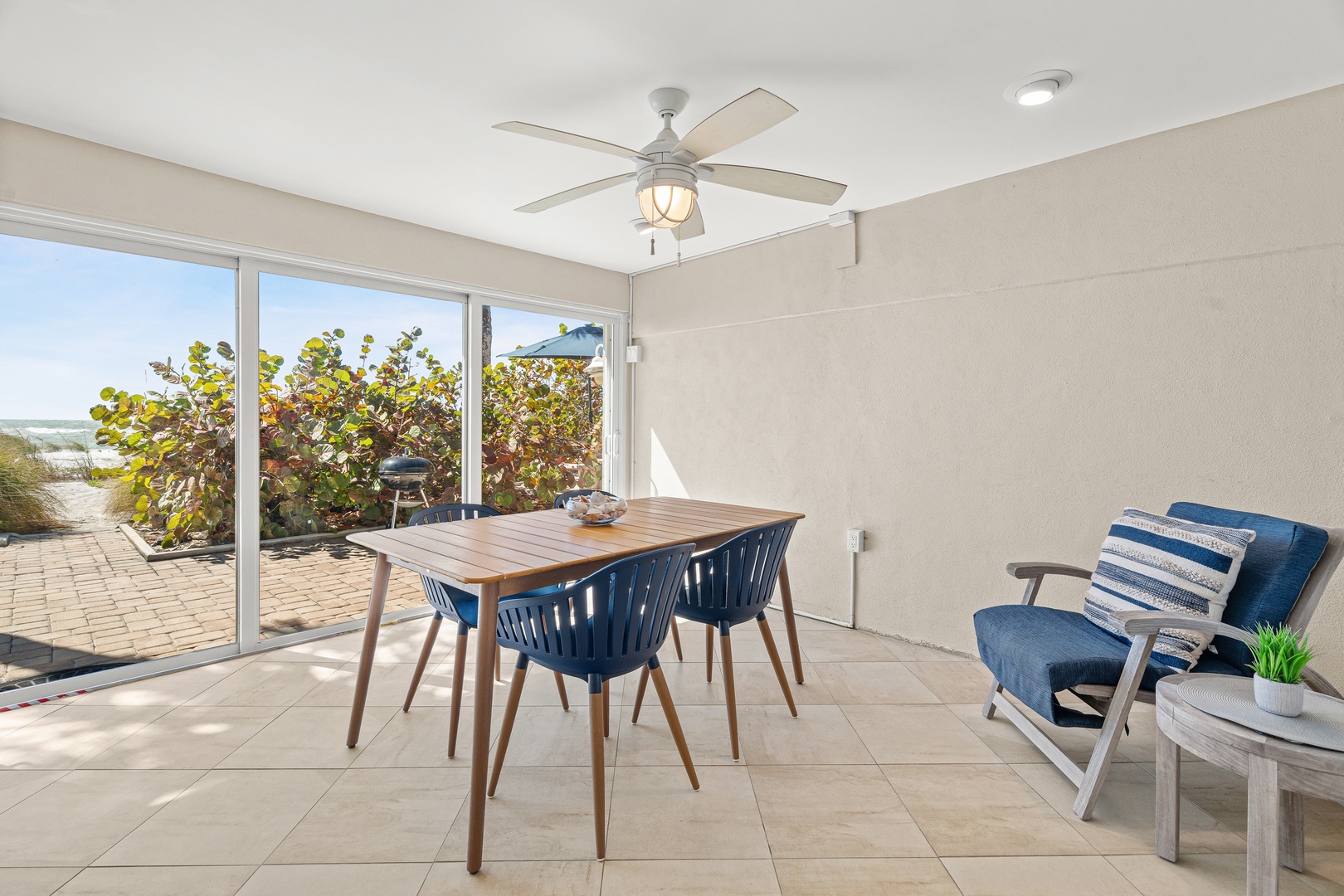 Gather around your stylish dining table with beach views through floor-to-ceiling windows. The coastal breeze flows through while you enjoy meals.