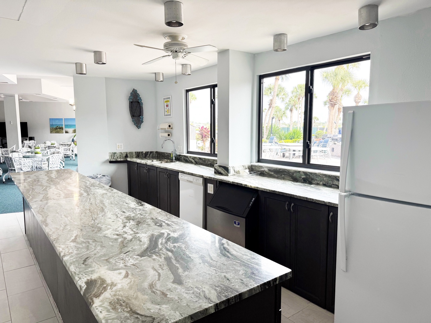 Your sleek kitchen features stunning marble countertops and modern appliances, perfect for preparing meals while enjoying tropical views.