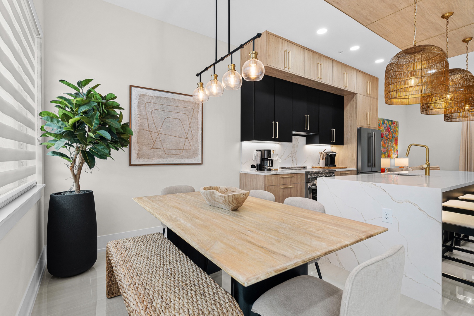 Your bright, modern dining area flows seamlessly into a sleek kitchen with warm wood tones, marble accents, and stylish pendant lighting—perfect for morning coffee or evening gatherings.
