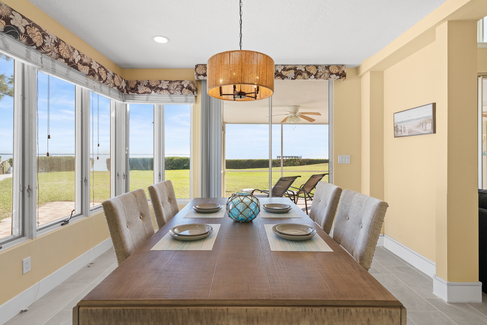 Gather around this elegant dining table for memorable meals with stunning views of green fields through floor-to-ceiling windows.