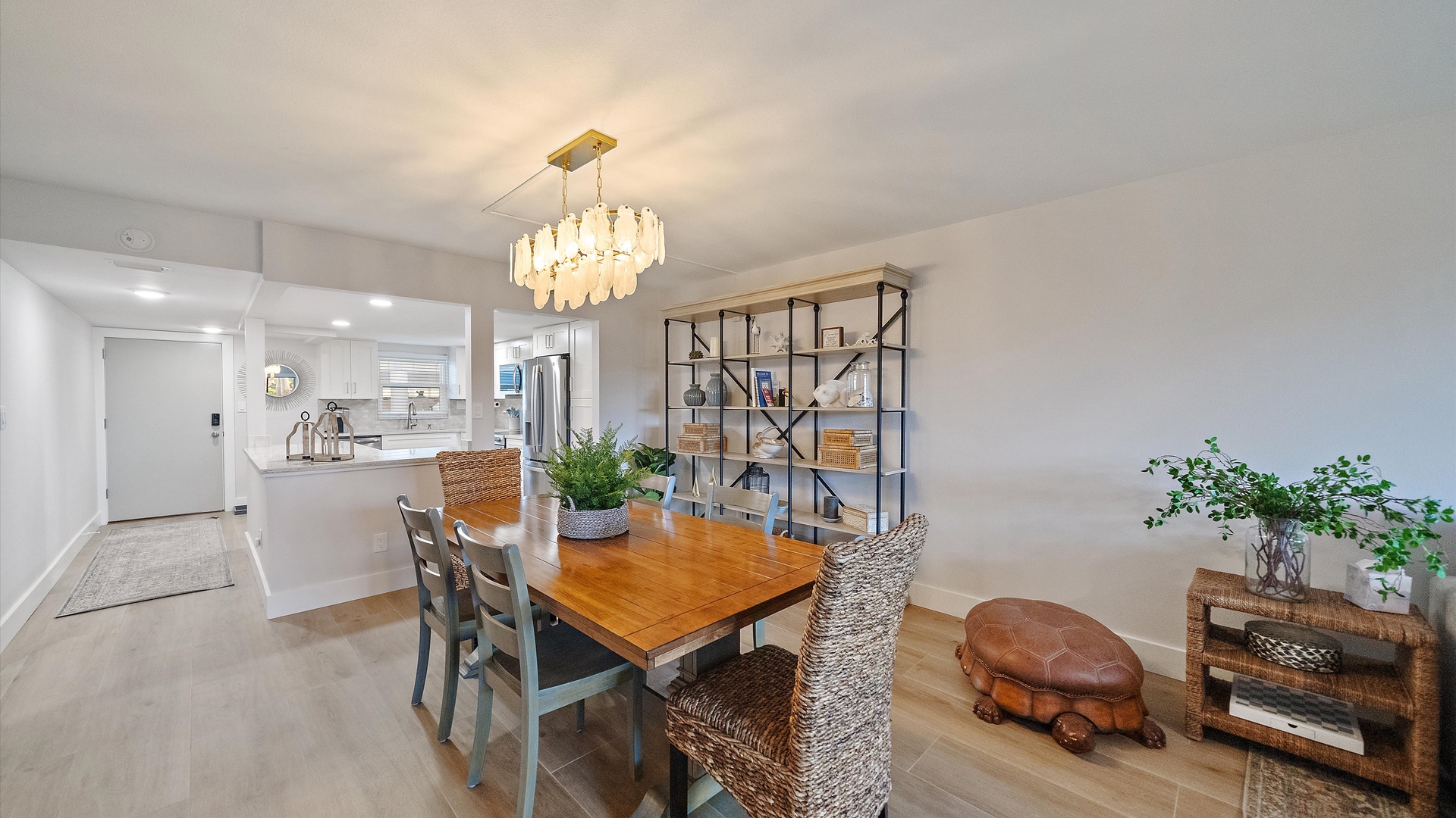 Gather around your elegant dining table beneath a stunning chandelier, with the modern kitchen just steps away for easy entertaining.