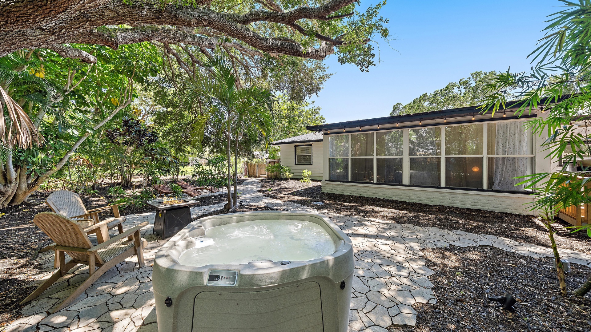 Soak in your private hot tub under the shade of mature trees, surrounded by lush tropical landscaping and peaceful garden seating areas.