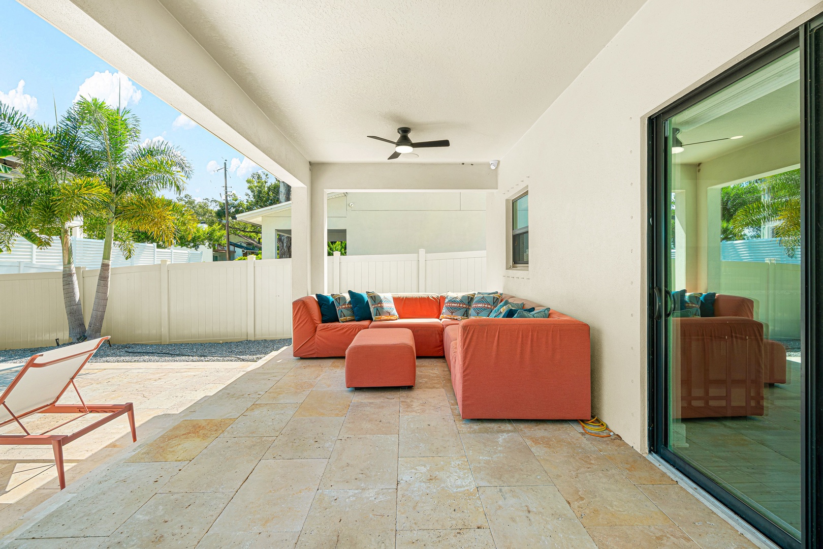 Sink into your private covered patio, where vibrant coral seating and tropical palm views create the perfect spot for morning coffee or evening relaxation.