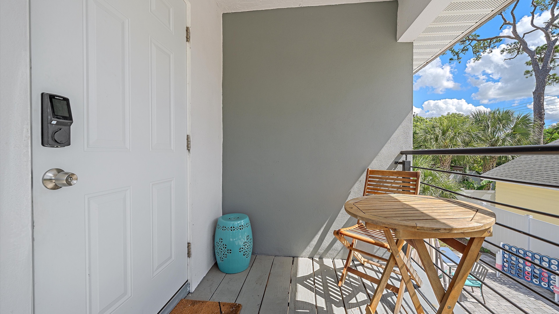 Step onto your private balcony, where a sunny bistro set awaits beneath swaying palms and bright blue skies—your perfect spot for morning coffee or evening relaxation.