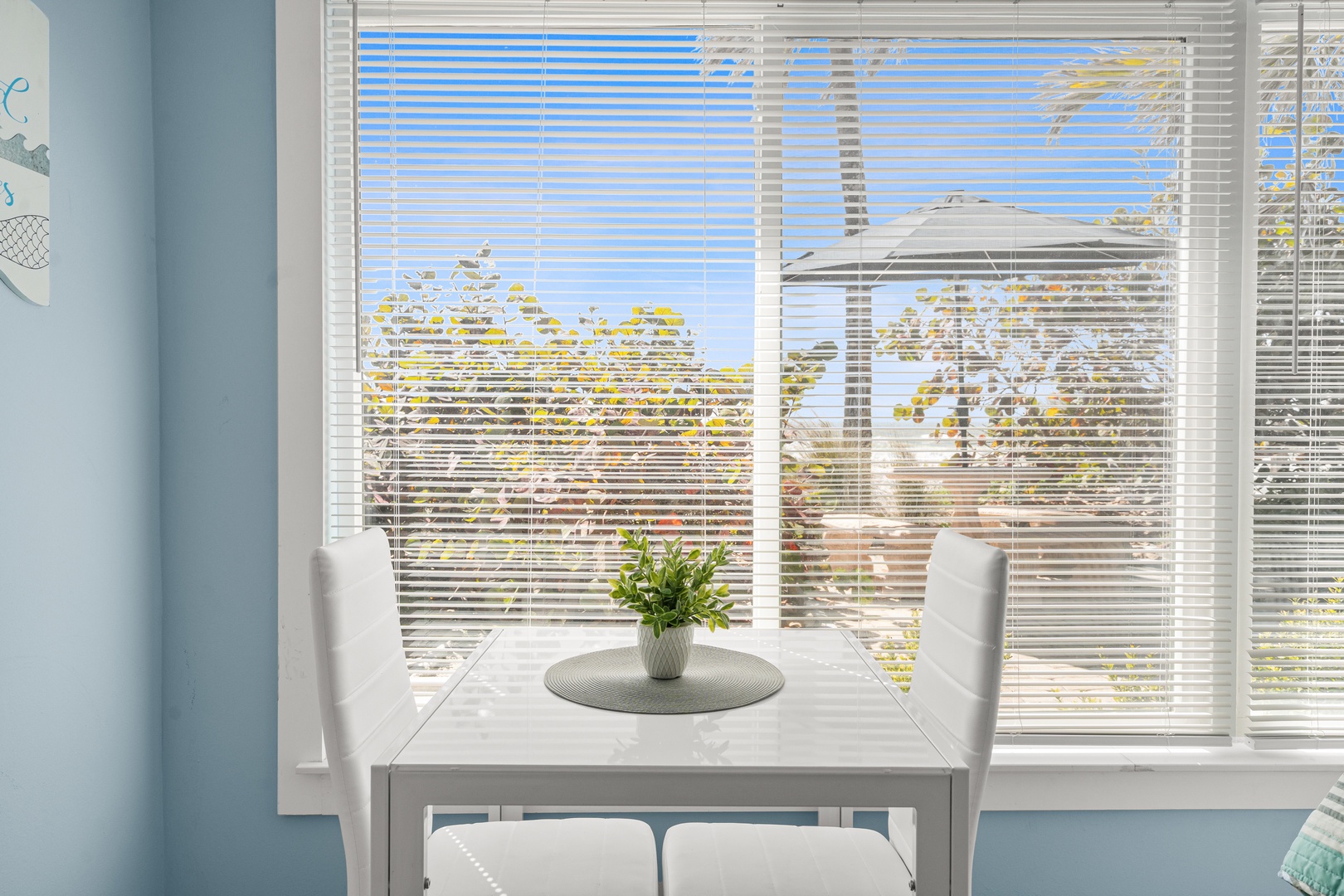 Your bright dining space overlooks peaceful neighborhood views through elegant blinds, perfect for morning coffee or evening meals.