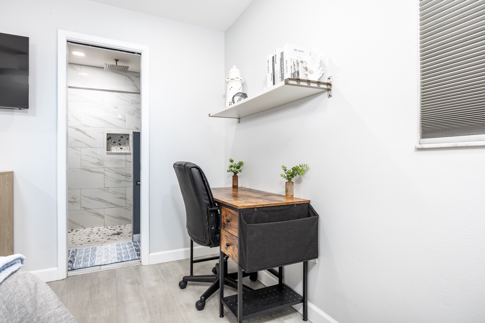 Your dedicated workspace awaits with a stylish desk, ergonomic chair, and natural light streaming through the window blinds.