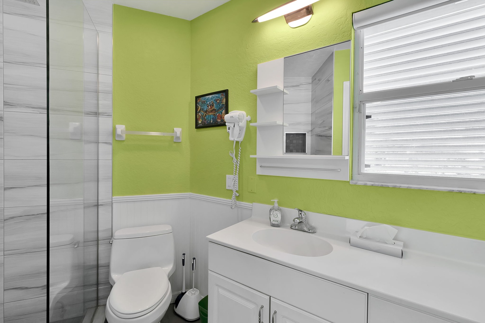 Step into your private bathroom, where fresh green walls and bright white fixtures create a cheerful, welcoming space. Your vanity offers plenty of counter space, and the glass shower awaits for refreshing starts to your days.