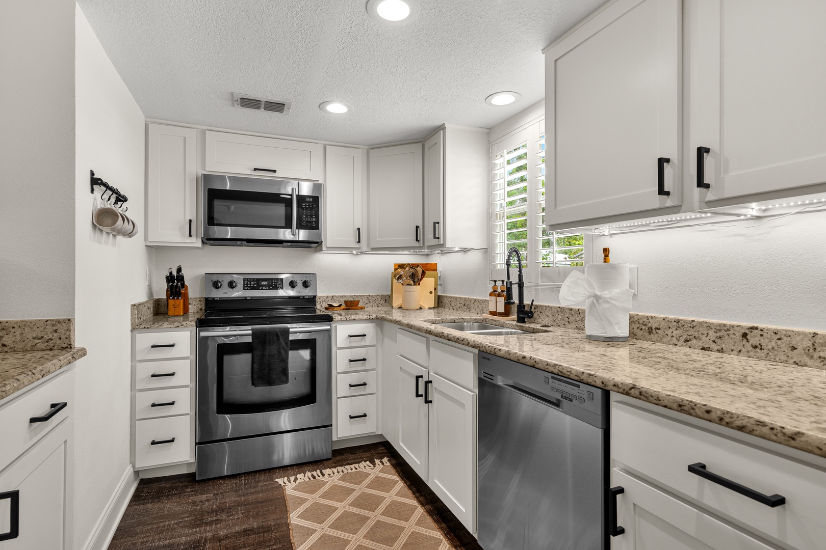 Your fully equipped kitchen features stainless-steel appliances, granite countertops, and bright white cabinetry—perfect for preparing meals in comfort during your stay.