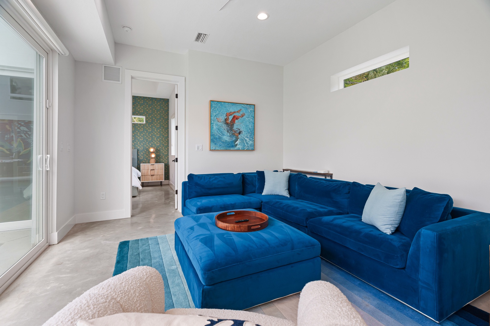Sink into plush velvet seating in your bright living area, where coastal-inspired art and natural light create an effortlessly stylish retreat for relaxing.