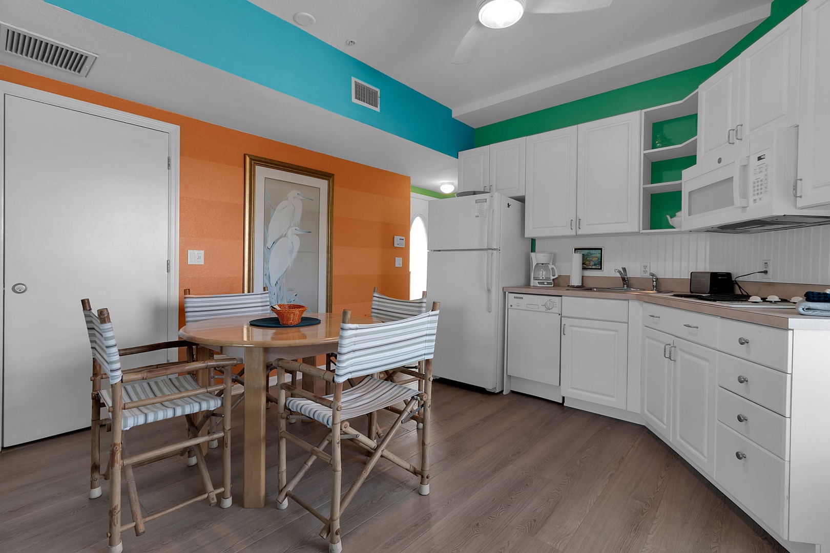 Gather around your own dining table in a cheerfully painted kitchen fully equipped with everything you need, from a full fridge to a microwave for easy meal prep.